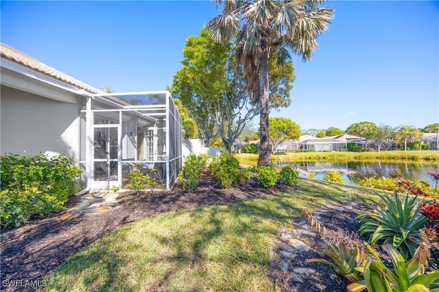 view of yard featuring a water view and glass enclosure