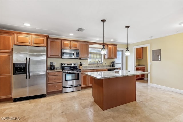 kitchen with a kitchen island, a sink, visible vents, appliances with stainless steel finishes, and electric panel