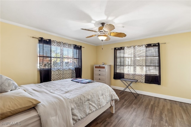 bedroom with a ceiling fan, crown molding, baseboards, and wood finished floors