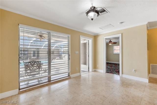 spare room with visible vents, crown molding, and baseboards