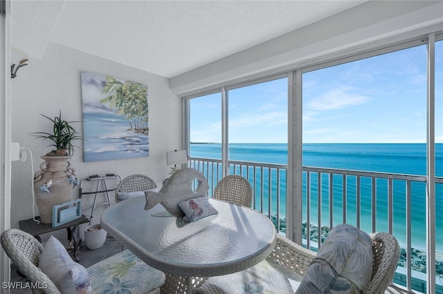 sunroom featuring a water view