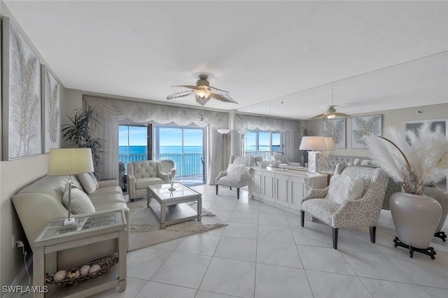 living room featuring a water view, ceiling fan, and light tile patterned floors