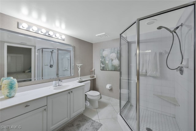 bathroom with vanity, toilet, tile patterned floors, and walk in shower