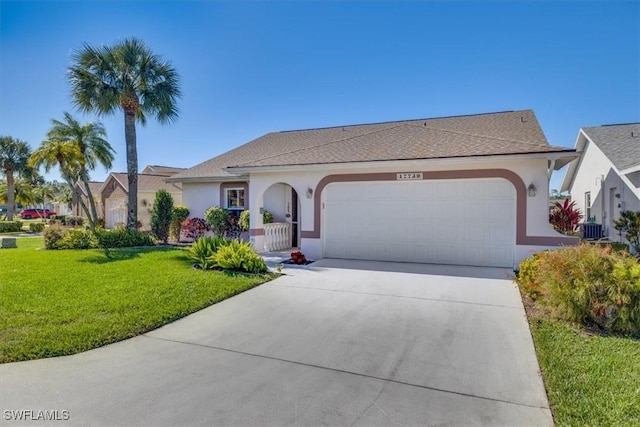 view of front of house with a garage, central AC unit, and a front yard