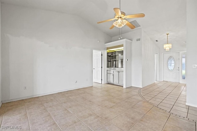 unfurnished living room with high vaulted ceiling, light tile patterned flooring, and ceiling fan with notable chandelier