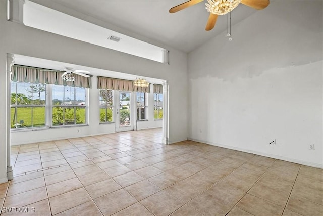 tiled empty room featuring vaulted ceiling, a healthy amount of sunlight, and ceiling fan