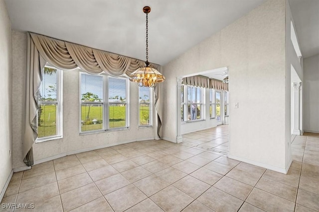 unfurnished room featuring lofted ceiling, an inviting chandelier, and light tile patterned floors