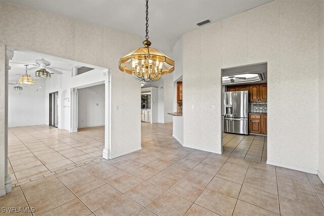 unfurnished dining area with a chandelier and light tile patterned flooring