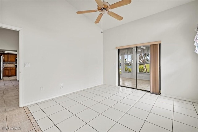 tiled empty room with ceiling fan and high vaulted ceiling