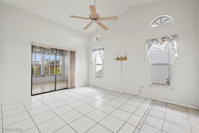 tiled empty room with ceiling fan and high vaulted ceiling