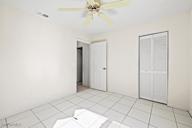 unfurnished bedroom with ceiling fan, a closet, and light tile patterned floors