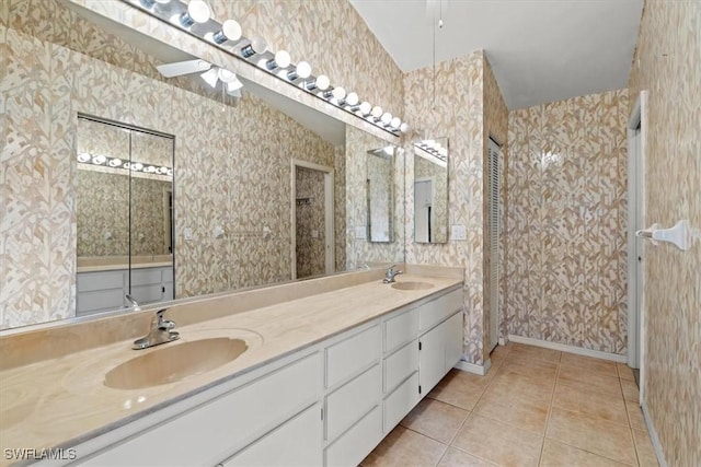 full bath featuring wallpapered walls, a sink, and tile patterned floors