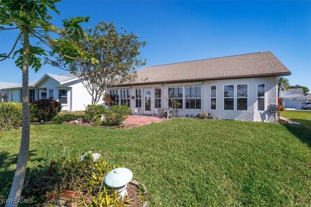 back of house featuring stucco siding, a yard, and a patio