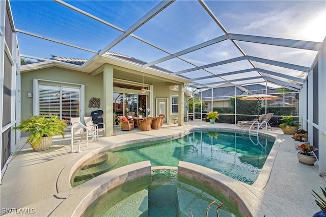 view of swimming pool with a pool with connected hot tub, glass enclosure, and a patio