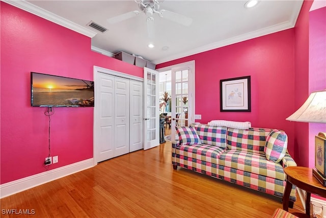 bedroom featuring baseboards, wood finished floors, visible vents, and crown molding