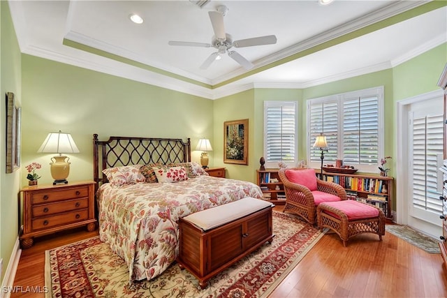 bedroom featuring a ceiling fan, baseboards, ornamental molding, and wood finished floors