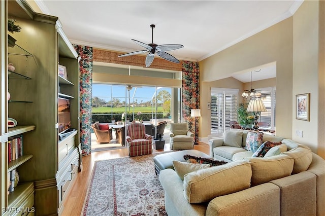 living area featuring a wealth of natural light, a ceiling fan, light wood-style flooring, and crown molding