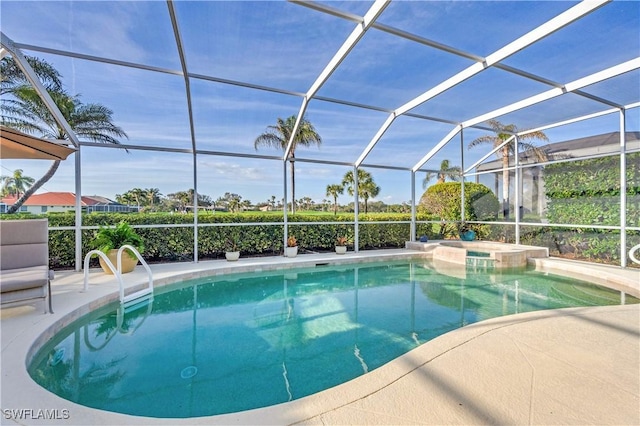 view of pool featuring a pool with connected hot tub, a lanai, and a patio