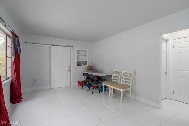 dining area with built in features, a barn door, and light tile patterned flooring