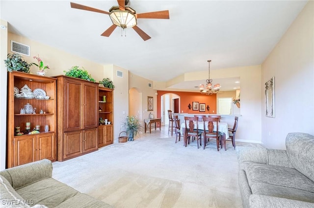 carpeted dining area featuring lofted ceiling and ceiling fan with notable chandelier