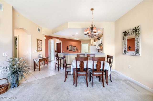 dining space with a notable chandelier and light colored carpet