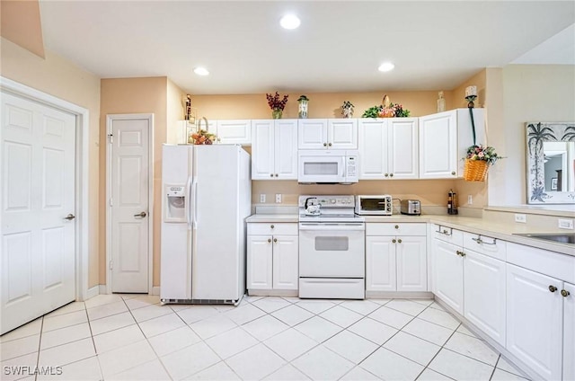 kitchen featuring white cabinetry, light tile patterned floors, white appliances, and sink