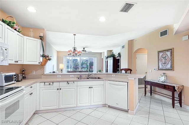 kitchen with light tile patterned floors, white appliances, white cabinetry, hanging light fixtures, and kitchen peninsula