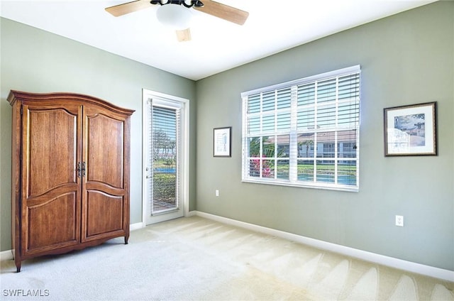 unfurnished bedroom featuring access to outside, light colored carpet, and ceiling fan