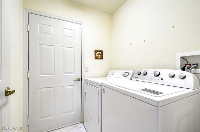 washroom with washer and dryer and light tile patterned floors