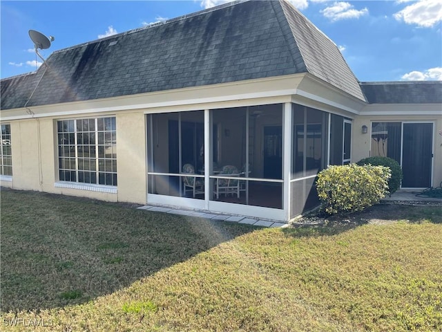 back of house featuring a sunroom and a lawn