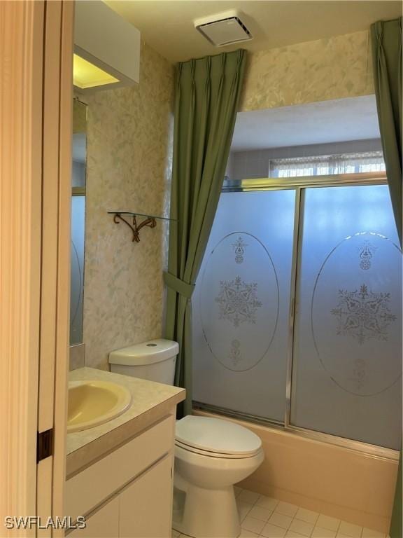 full bathroom featuring vanity, tile patterned floors, shower / bath combination with glass door, and toilet