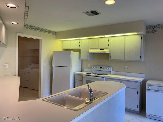 kitchen featuring light tile patterned flooring, separate washer and dryer, sink, and white appliances