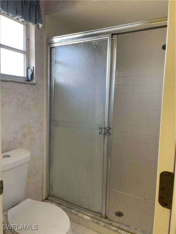 bathroom with an enclosed shower and toilet