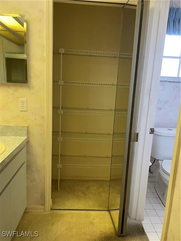 bathroom featuring tile patterned flooring, vanity, and toilet