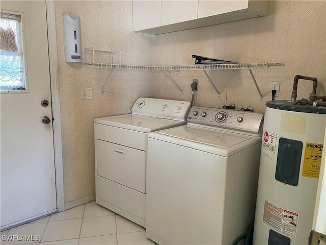 washroom with cabinets, washer and clothes dryer, electric water heater, and light tile patterned floors