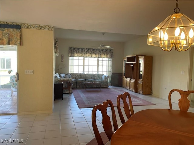 tiled dining area with ceiling fan with notable chandelier