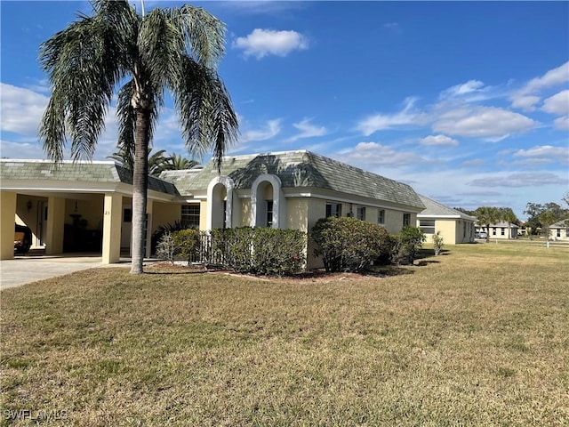 ranch-style home featuring a front lawn and a carport