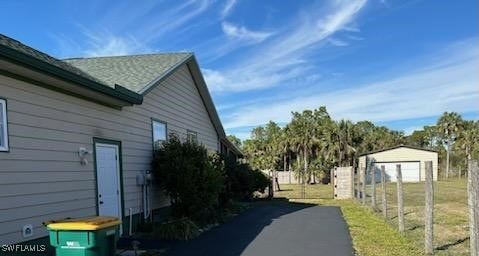 view of side of property with a lawn and fence