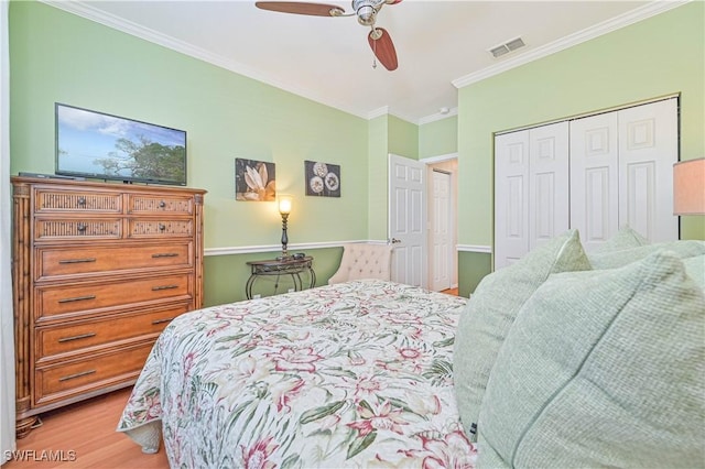 bedroom featuring light hardwood / wood-style flooring, ornamental molding, a closet, and ceiling fan