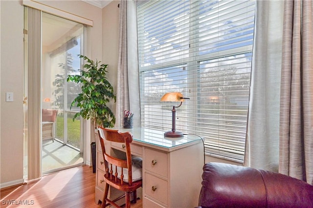 office area with ornamental molding and light hardwood / wood-style floors