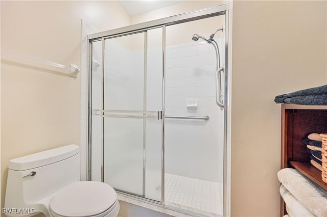 bathroom featuring an enclosed shower and toilet