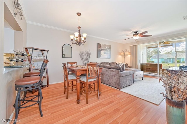 dining area with crown molding, ceiling fan with notable chandelier, and light hardwood / wood-style flooring