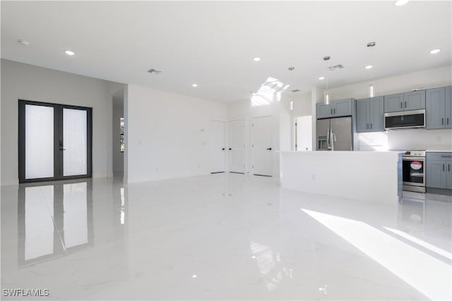 interior space with gray cabinets, a kitchen island, appliances with stainless steel finishes, and decorative light fixtures