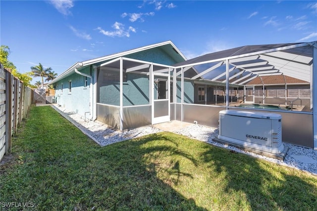 rear view of house with glass enclosure and a lawn