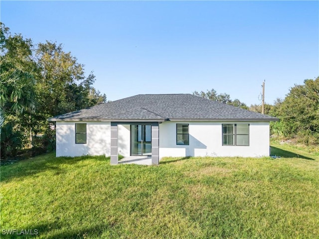 rear view of house featuring a lawn