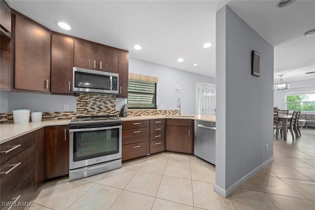 kitchen featuring sink, light tile patterned floors, backsplash, stainless steel appliances, and dark brown cabinetry