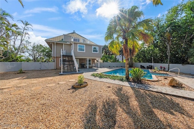 back of property with a fenced in pool and a patio area