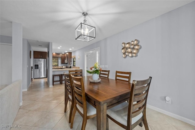 dining space with light tile patterned floors and a notable chandelier