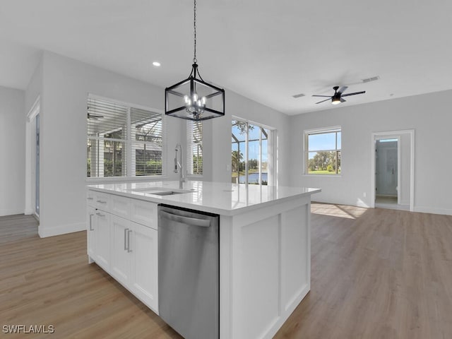 kitchen featuring white cabinetry, dishwasher, sink, an island with sink, and hanging light fixtures