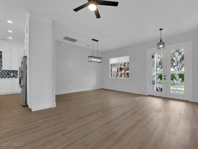 unfurnished living room featuring light hardwood / wood-style flooring and ceiling fan